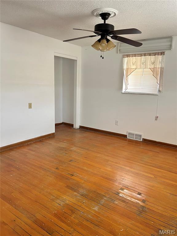 3757 Itaska St, Saint Louis, MO 63116 - spare room featuring hardwood / wood-style floors, ceiling fan, a textured ceiling, and baseboards