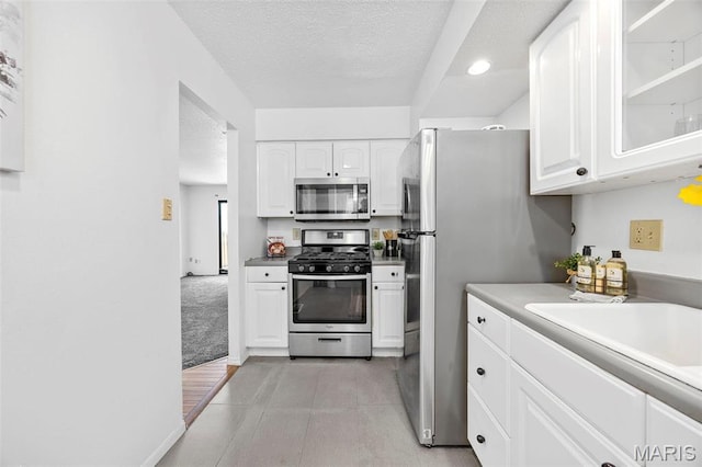 1747 Russet Valley Dr, Saint Louis, MO 63146 - kitchen featuring appliances with stainless steel finishes, white cabinetry, a textured ceiling, glass insert cabinets, and recessed lighting