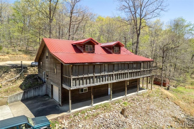 124 Wayne 527, Greenville, MO 63944 - view of front of property featuring metal roof, a wooded view, board and batten siding, and a deck