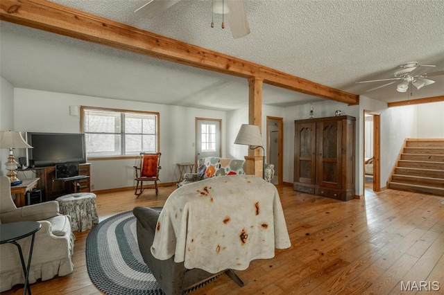 124 Wayne 527, Greenville, MO 63944 - living room featuring ceiling fan, beamed ceiling, a textured ceiling, wood-type flooring, and stairway