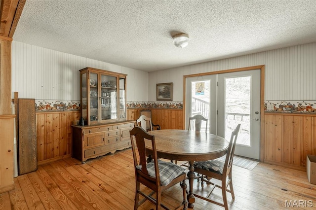 124 Wayne 527, Greenville, MO 63944 - dining space featuring wooden walls, light wood-style flooring, wainscoting, and a textured ceiling