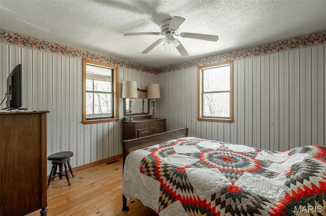 124 Wayne 527, Greenville, MO 63944 - bedroom with light wood finished floors, multiple windows, a textured ceiling, baseboards, and ceiling fan