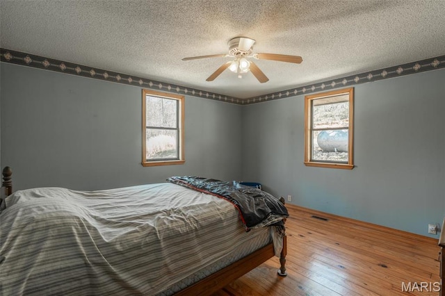 124 Wayne 527, Greenville, MO 63944 - bedroom featuring a textured ceiling, hardwood / wood-style flooring, multiple windows, and ceiling fan