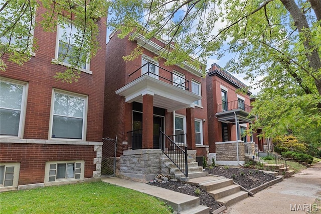2220 Nebraska Ave, Saint Louis, MO 63104 - view of front facade featuring brick siding, a front yard, and a balcony
