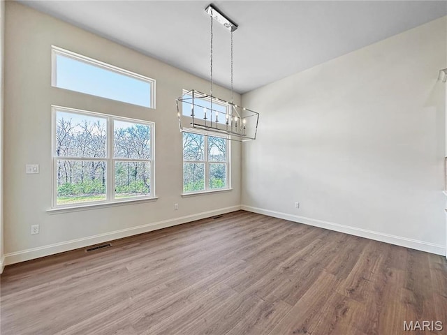 204 Great Bear Pass, Foristell, MO 63348 - unfurnished dining area featuring a chandelier, wood finished floors, and baseboards