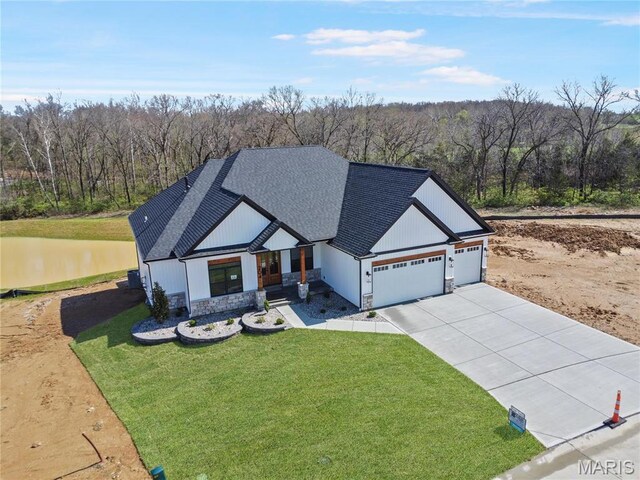 204 Great Bear Pass, Foristell, MO 63348 - modern inspired farmhouse with driveway, roof with shingles, a garage, a wooded view, and stone siding