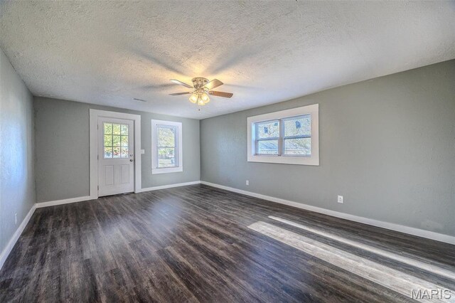 450 Michigan, Lebanon, MO 65536 - spare room featuring a textured ceiling, dark wood-type flooring, baseboards, and ceiling fan