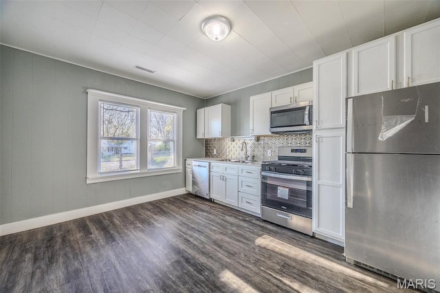 450 Michigan, Lebanon, MO 65536 - kitchen featuring stainless steel appliances, a sink, dark wood-type flooring, and white cabinetry