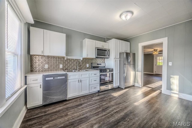 450 Michigan, Lebanon, MO 65536 - kitchen with stainless steel appliances, a sink, dark wood-style floors, light countertops, and backsplash
