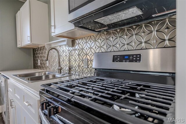450 Michigan, Lebanon, MO 65536 - kitchen with stainless steel gas range oven, white cabinets, extractor fan, a sink, and light countertops
