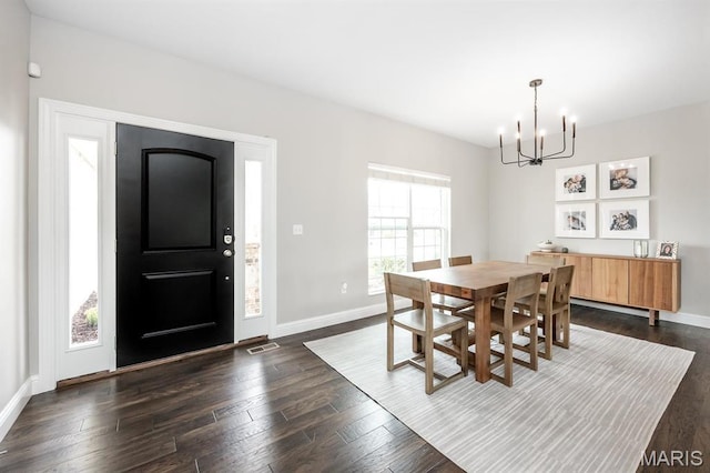 dining room with a chandelier, baseboards, and dark wood-style flooring