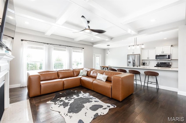 living room featuring ceiling fan, dark wood-style flooring, a high end fireplace, coffered ceiling, and beam ceiling