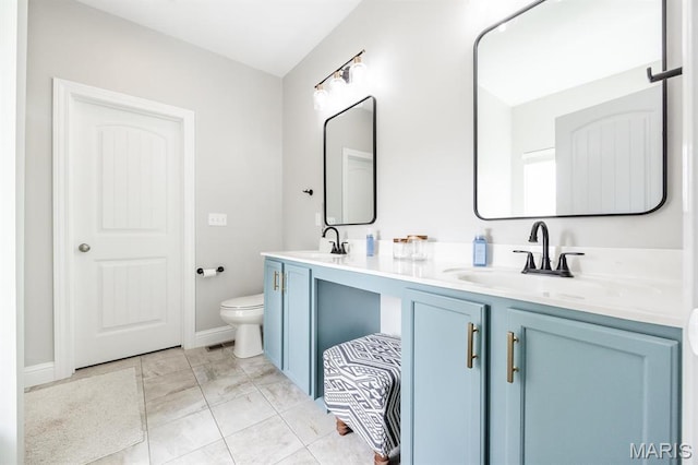 bathroom featuring toilet, double vanity, and marble look tile flooring