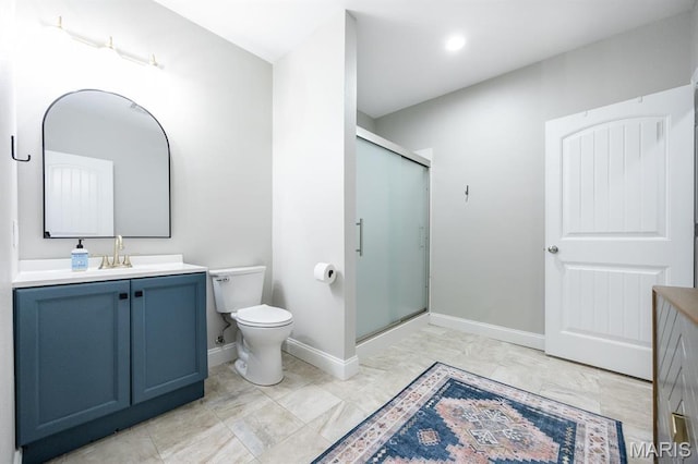 full bath featuring vanity, toilet, a shower stall, and baseboards