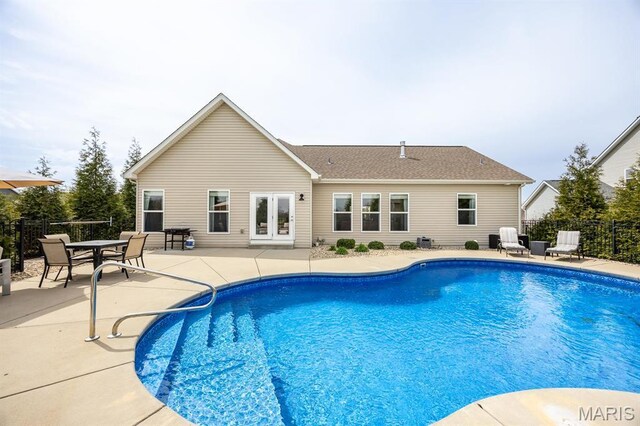 view of pool with a patio, fence, and french doors
