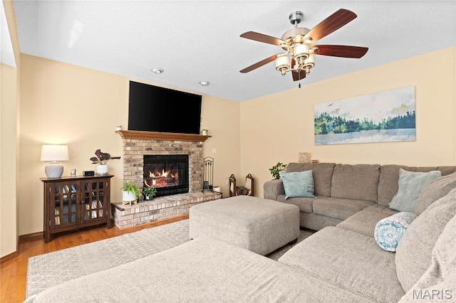 living area featuring ceiling fan, wood finished floors, a fireplace, and recessed lighting
