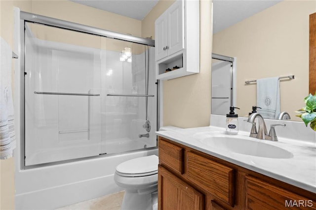 bathroom featuring toilet, vanity, bath / shower combo with glass door, and tile patterned floors
