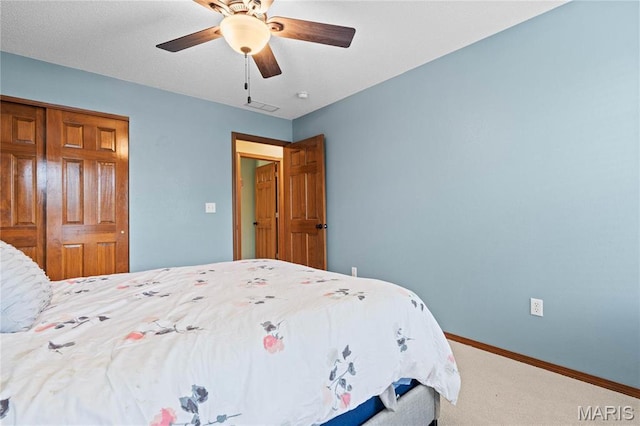 bedroom featuring carpet floors, a closet, baseboards, and a ceiling fan