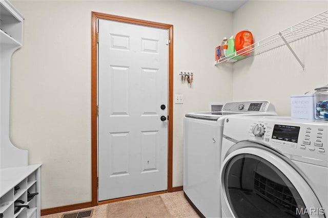 washroom featuring washing machine and clothes dryer and baseboards
