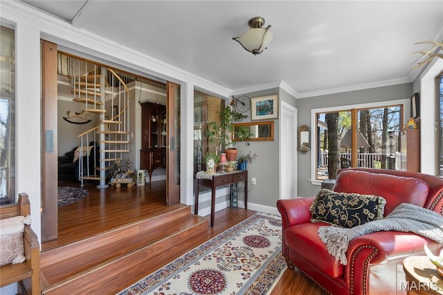 living area with stairs, wood finished floors, crown molding, and baseboards