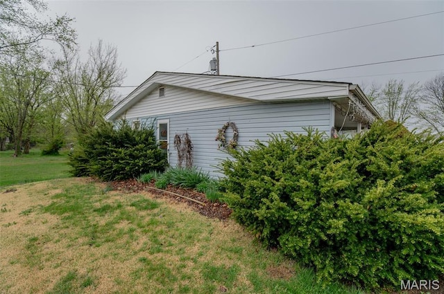 view of side of home with a yard