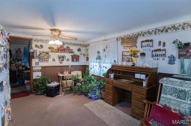 miscellaneous room featuring carpet flooring, a ceiling fan, and a wainscoted wall