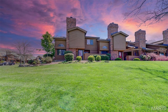 228 Hemingway Ln Unit F, Weldon Spring, MO 63304 - back of property at dusk featuring a lawn and a chimney