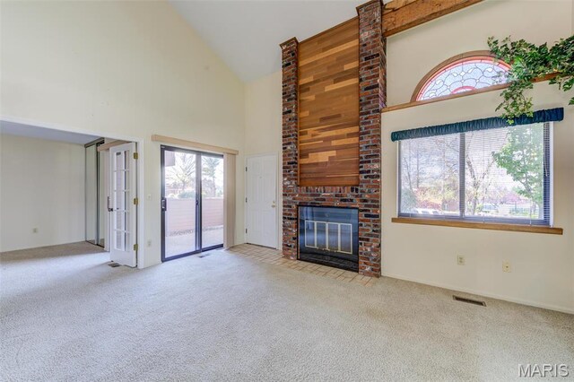 228 Hemingway Ln Unit F, Weldon Spring, MO 63304 - unfurnished living room featuring high vaulted ceiling, carpet flooring, a brick fireplace, and plenty of natural light