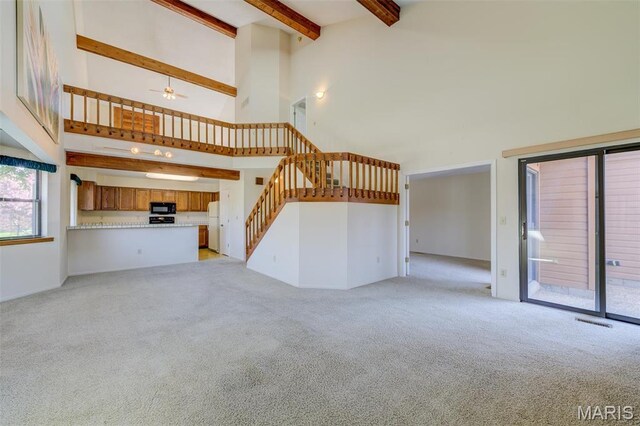 228 Hemingway Ln Unit F, Weldon Spring, MO 63304 - unfurnished living room with a towering ceiling, light carpet, beam ceiling, stairway, and a ceiling fan