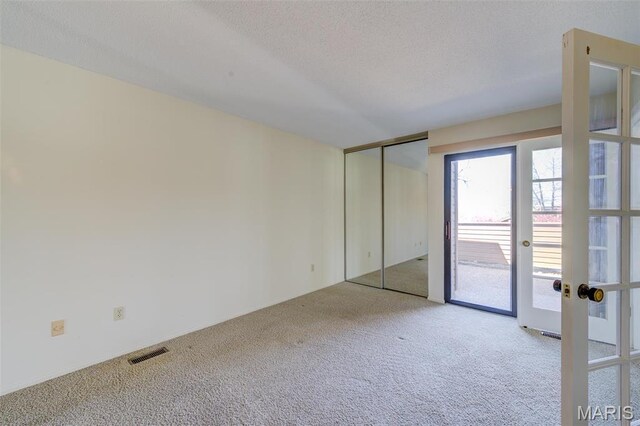 228 Hemingway Ln Unit F, Weldon Spring, MO 63304 - unfurnished room featuring carpet flooring, french doors, and a textured ceiling