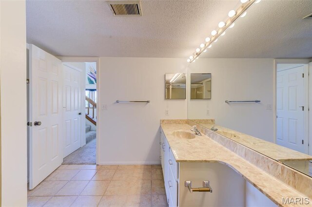 228 Hemingway Ln Unit F, Weldon Spring, MO 63304 - bathroom featuring a textured ceiling, vanity, baseboards, and tile patterned floors