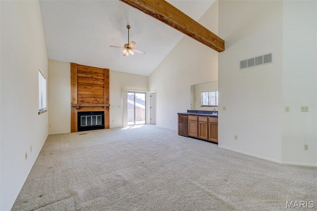 228 Hemingway Ln Unit F, Weldon Spring, MO 63304 - unfurnished living room with high vaulted ceiling, ceiling fan, carpet flooring, beamed ceiling, and a tiled fireplace