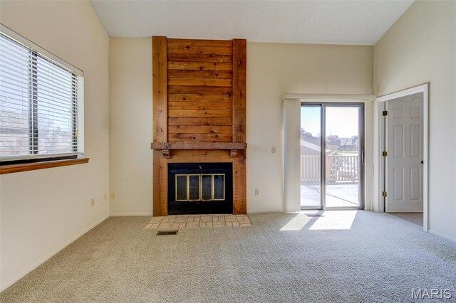 228 Hemingway Ln Unit F, Weldon Spring, MO 63304 - unfurnished living room with carpet floors, healthy amount of natural light, and a fireplace with flush hearth