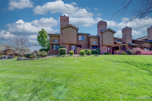 228 Hemingway Ln Unit F, Weldon Spring, MO 63304 - rear view of house featuring a yard and a chimney
