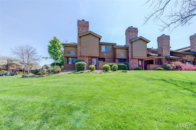 228 Hemingway Ln Unit F, Weldon Spring, MO 63304 - rear view of property with a yard, a chimney, and brick siding
