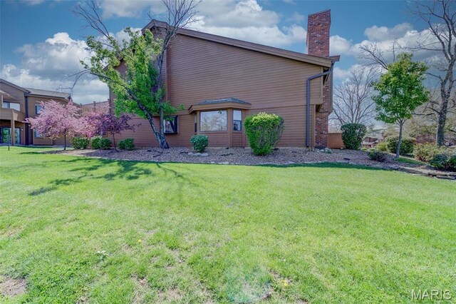 228 Hemingway Ln Unit F, Weldon Spring, MO 63304 - view of home's exterior with a chimney and a yard