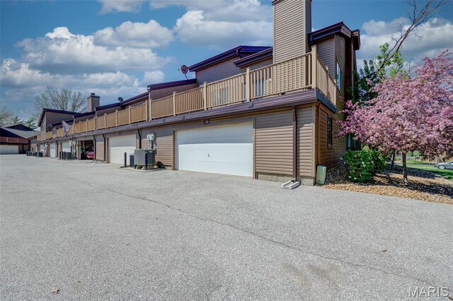 228 Hemingway Ln Unit F, Weldon Spring, MO 63304 - view of side of home featuring a chimney, a balcony, and central AC unit