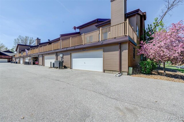 228 Hemingway Ln Unit F, Weldon Spring, MO 63304 - back of house with a chimney, a balcony, and central AC