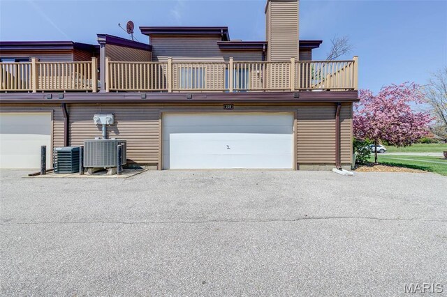 228 Hemingway Ln Unit F, Weldon Spring, MO 63304 - garage featuring central AC unit and asphalt driveway