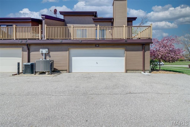 228 Hemingway Ln Unit F, Weldon Spring, MO 63304 - rear view of property featuring a garage, a balcony, asphalt driveway, and a chimney