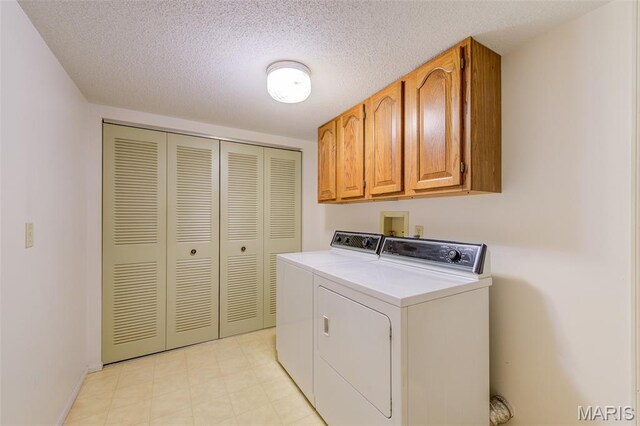 228 Hemingway Ln Unit F, Weldon Spring, MO 63304 - laundry room featuring washer and clothes dryer, cabinet space, and a textured ceiling