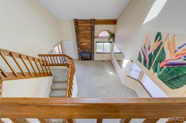 228 Hemingway Ln Unit F, Weldon Spring, MO 63304 - stairway with carpet, high vaulted ceiling, and a fireplace