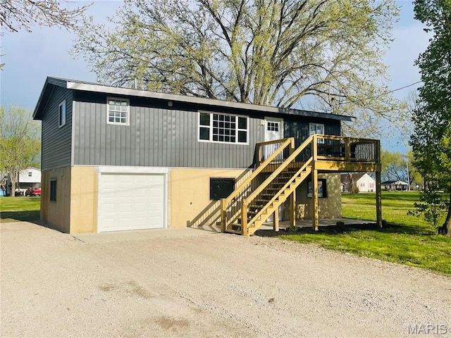 view of front of property featuring dirt driveway, a wooden deck, stairs, and an attached garage