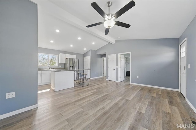 unfurnished living room featuring ceiling fan, a sink, light wood-type flooring, recessed lighting, and baseboards
