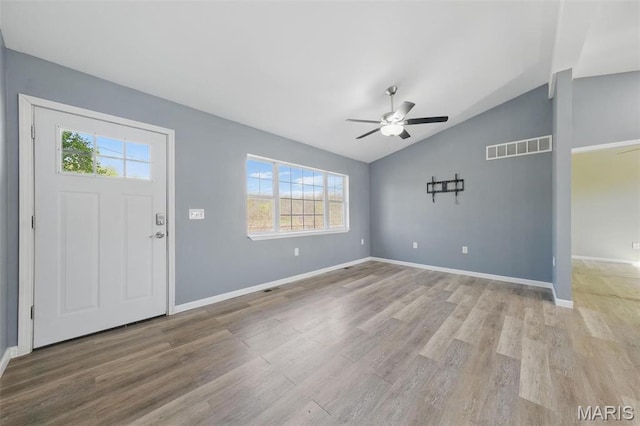 foyer with healthy amount of natural light, vaulted ceiling, ceiling fan, and light wood-style flooring
