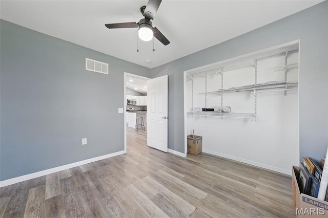 unfurnished bedroom featuring baseboards, wood finished floors, and a ceiling fan
