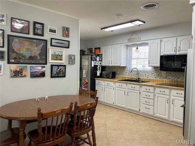 49 S St St, Piedmont, MO 63957 - kitchen featuring black microwave, a sink, backsplash, white cabinets, and crown molding