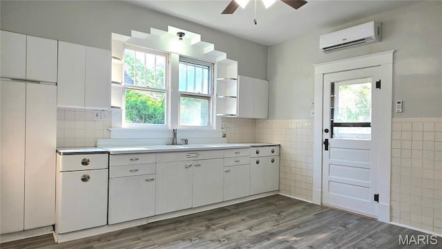 913 Maupin Ave, New Haven, MO 63068 - kitchen featuring tile walls, a sink, an AC wall unit, plenty of natural light, and ceiling fan