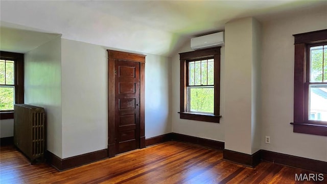 913 Maupin Ave, New Haven, MO 63068 - empty room with a wall mounted AC, radiator heating unit, wood finished floors, lofted ceiling, and baseboards
