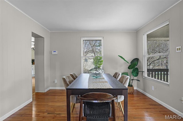 dining area featuring ornamental molding, wood finished floors, and baseboards